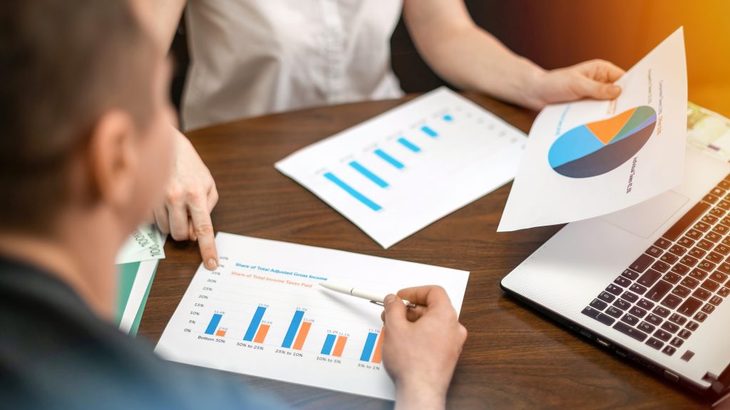 Woman showing a man finance consultation & advisory banking services. On Laptop, papers